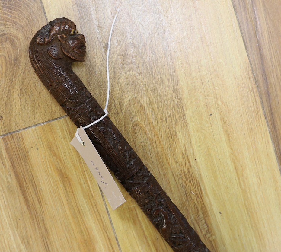 An Asian carved wood walking cane, 7 cm long.